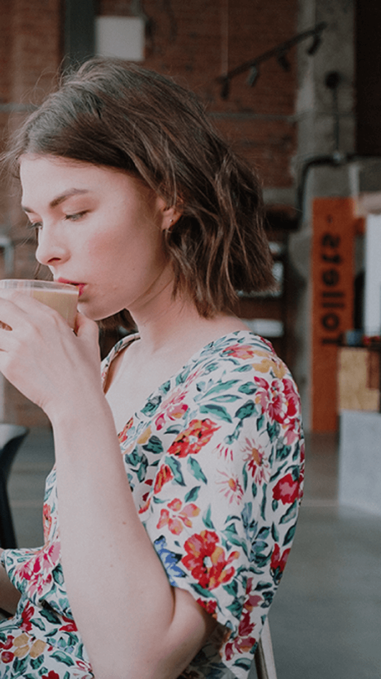 カフェでコーヒーを飲みながら読書する女性